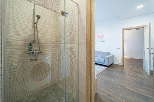a bathroom with a shower with a glass door at Žalgiris arena apartment with AC in Kaunas