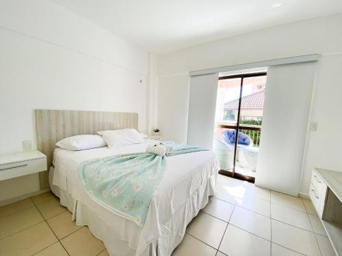 a bedroom with a bed with a teddy bear on it at Beverly Hills por Be My Guest in Aquiraz