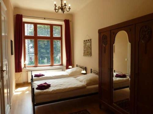 a bedroom with two beds and a large window at Fewo Gründerzeitflair in Görlitz
