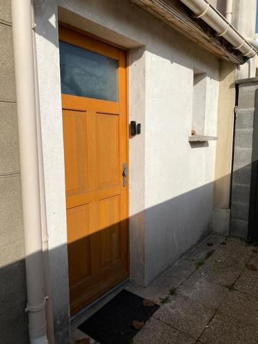 an orange door on a building with a sidewalk at BLUE NIGHT - Jacuzzi - Bord de Seine in Corbeil-Essonnes