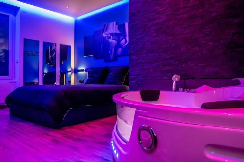 uma sala de estar com um sofá e uma banheira em BLUE NIGHT - Jacuzzi - Bord de Seine em Corbeil-Essonnes