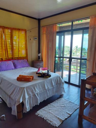 1 dormitorio con cama y ventana grande en Island samal overlooking view house with swimming pools en San Antonio