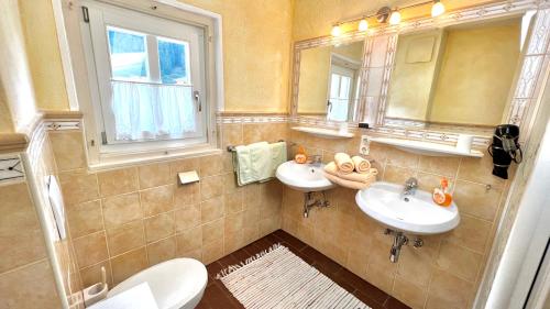 a bathroom with two sinks and a mirror at Ferienhaus Försterlisl in Kleinarl