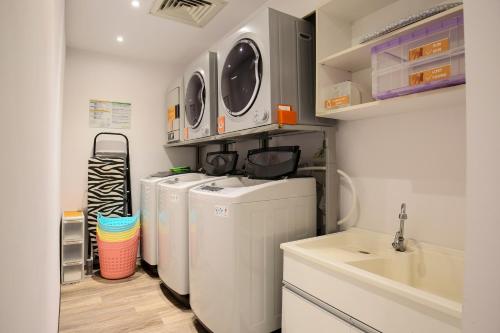 a laundry room with three washes and a sink at CityInn Hotel Taipei Station Branch III in Taipei