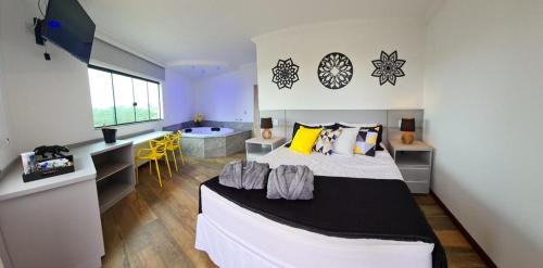 a bedroom with a large bed and a bathroom at Biz & Biu Pousada Lavras Novas in Lavras Novas