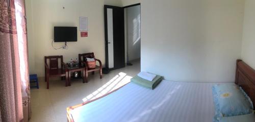 a bedroom with a bed and a room with a tv at Nhà nghỉ Tâm Cường in Diện Biên Phủ