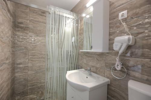 een badkamer met een toilet, een wastafel en een douche bij PENSIUNE RESTAURANT LIANA in Mehadia