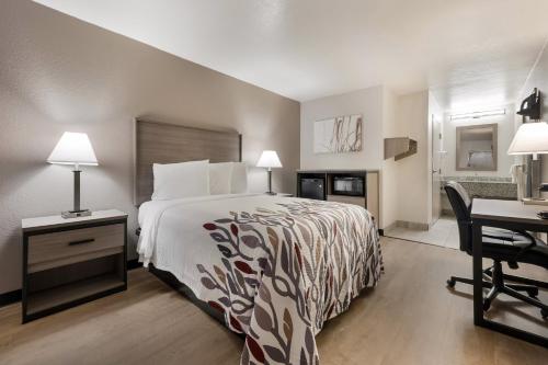 a hotel room with a bed and a desk with a computer at Red Roof Inn Birmingham South in Birmingham