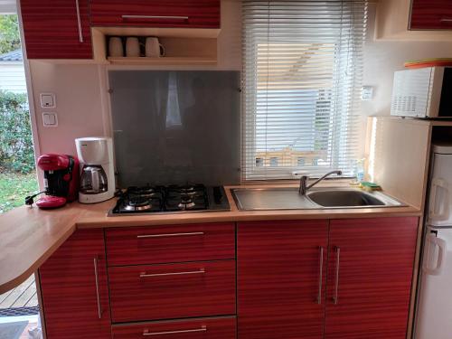 une cuisine avec un évier et une cuisinière four supérieur dans l'établissement CARNAC CAMPING, à Carnac