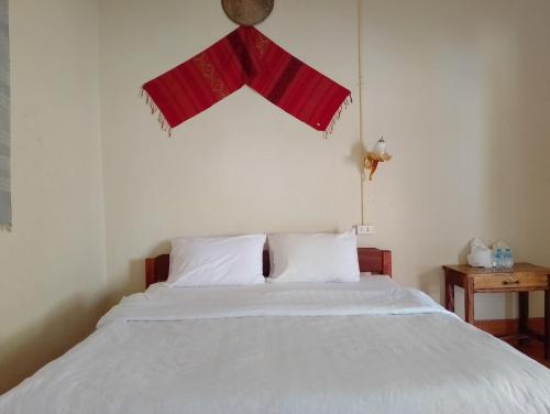 Schlafzimmer mit einem weißen Bett und einem roten Fenster in der Unterkunft Meexai Guesthouse in Nongkhiaw