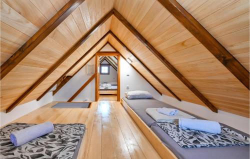 two beds in a attic room with wooden ceilings at Stunning Home In Klostar Ivanic With Sauna in Kloštar Ivanić