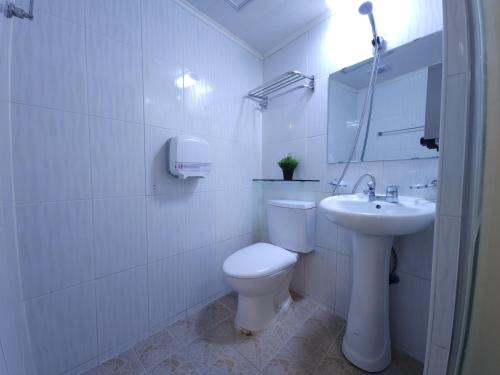 a white bathroom with a toilet and a sink at OYO Hostel Myeongdong 3 in Seoul