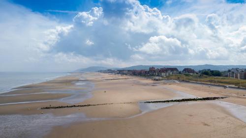 an aerial view of a beach with buildings and the ocean at Thalazur Cabourg - Hôtel & Spa in Cabourg