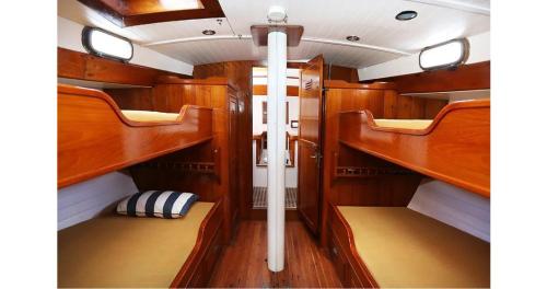 a boat with wooden paneling and shelves in a room at Classic sailing ship in center of Enkhuizen! in Enkhuizen