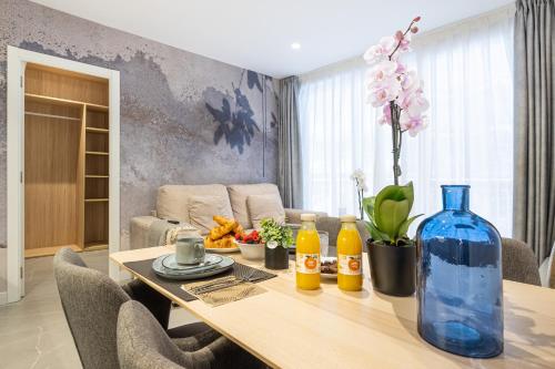 einen Esstisch mit einer blauen Vase darauf in der Unterkunft Mara Boutique Apartments in Benidorm