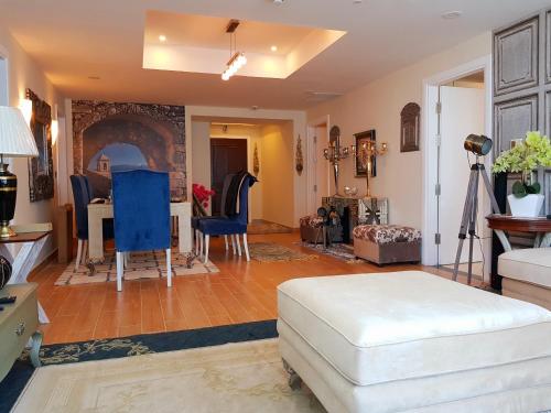 a living room with a table and blue chairs at Royal Residencia Centaurus in Islamabad