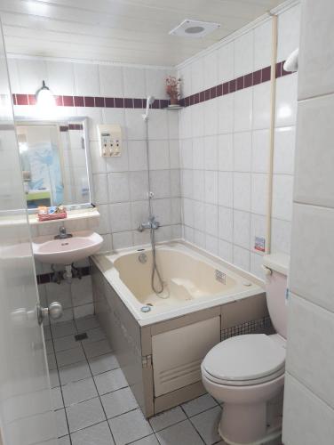 a bathroom with a tub and a toilet and a sink at Beethoven Express Hotel in Zhongli