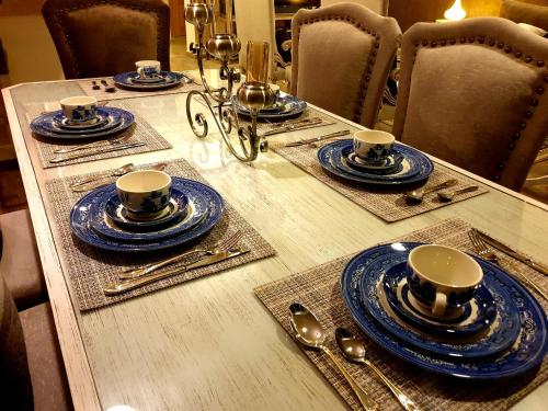 a table with blue and white plates and cups on it at Royal Residencia Centaurus in Islamabad
