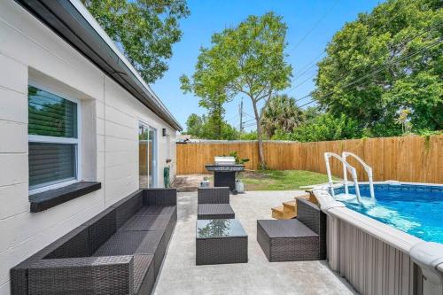 a backyard with a swimming pool and a patio with chairs at Cozy & Fully Renovated FREE Heated Pool Home! in Largo