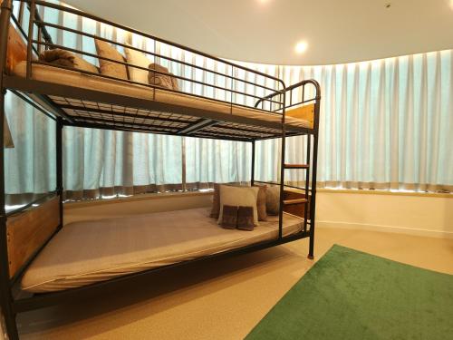 ソウルにあるOYO Hostel Myeongdong 3の緑の敷物が備わるドミトリールームの二段ベッド2台