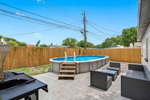 a backyard with a swimming pool and a wooden fence at Cozy & Fully Renovated FREE Heated Pool Home! in Largo