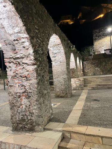 a stone wall with an archway on a street at night at 4ROOMS b&b - HOLIDAY HOME in Lamezia Terme