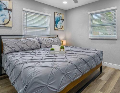 a large bed in a bedroom with two windows at Cozy & Fully Renovated FREE Heated Pool Home! in Largo