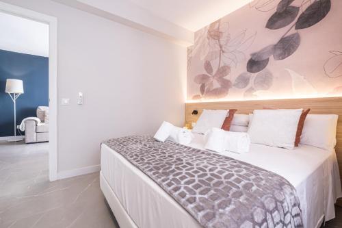 ein Schlafzimmer mit einem großen Bett und einem Gemälde an der Wand in der Unterkunft Mara Boutique Apartments in Benidorm