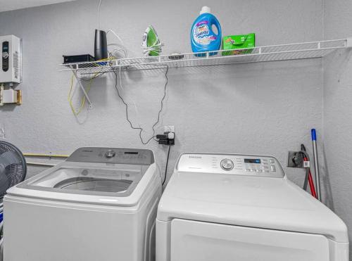 a laundry room with a washing machine and a drying rack at Cozy & Fully Renovated FREE Heated Pool Home! in Largo