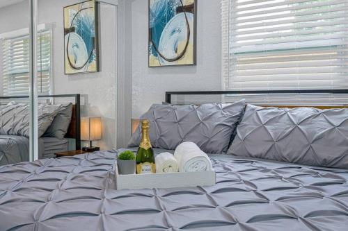 a bed with a tray of towels and a bottle of wine at Cozy & Fully Renovated FREE Heated Pool Home! in Largo