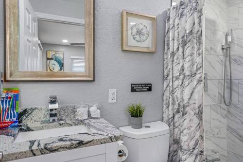 a bathroom with a toilet and a sink and a shower at Cozy & Fully Renovated FREE Heated Pool Home! in Largo