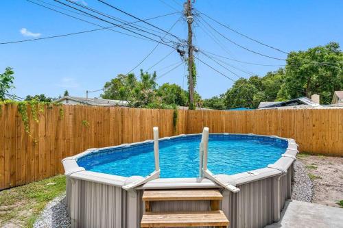 a swimming pool in front of a wooden fence at Cozy & Fully Renovated FREE Heated Pool Home! in Largo