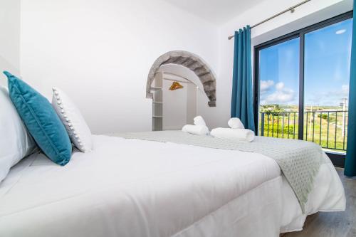 Un dormitorio blanco con una cama grande y una ventana en Green View Guest House, en Nordeste