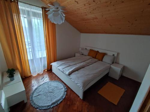 een kleine slaapkamer met een bed en een raam bij Alsoveto Apartment in Kosd