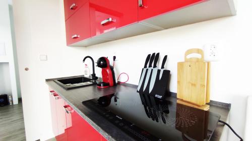 a kitchen with red cabinets and a black counter top at Ranch 66 - Moderní Tiny House Black Swallow ve stylu Route 66 se saunou a bazénem in Tršice