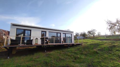 a tiny house sitting on top of a field at Ranch 66 - Moderní Tiny House Black Swallow ve stylu Route 66 se saunou a bazénem in Tršice