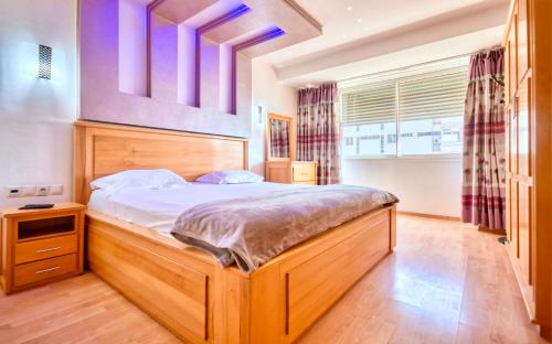 a bedroom with a large bed with a wooden headboard at Cruz Hyper centre 4 or 5 Px in Agadir