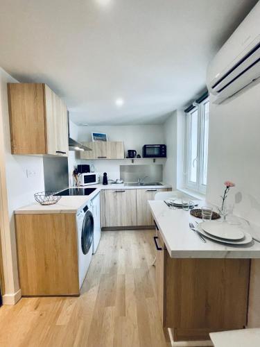 une cuisine avec des appareils électroménagers blancs et des armoires en bois dans l'établissement * Villa Adélaïde * Les Célestins *, à Vichy