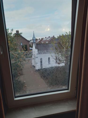 uma vista a partir de uma janela de um edifício antigo em Bed en Breakfast met patio en kippen em Thorn