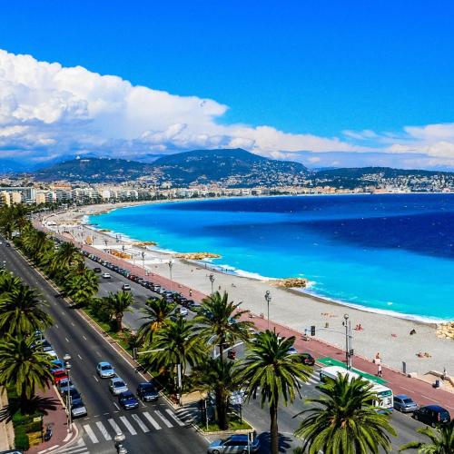 a view of a beach with palm trees and the ocean at Maison Casa Milesa - SPA, calme, 12 min mer, parking securisé in Nice
