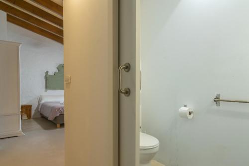 a bathroom with a toilet and a bed in a room at Son Indiot in Algaida