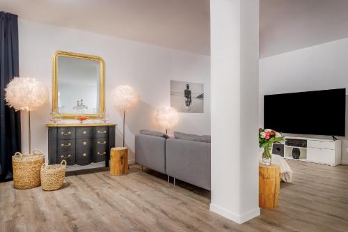 a living room with a couch and a mirror at Belfry & Spa by Ligne St Barth in Lourdes