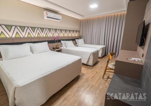 a hotel room with two beds and a television at Complexo Eco Cataratas Resort by SJ in Foz do Iguaçu
