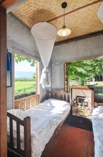 a bedroom with a bed and a large window at 467 Chiang Dao in Chiang Dao