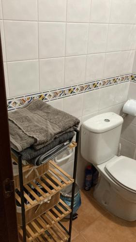 bagno con servizi igienici e mensola con asciugamani di MARTSARAs PLAYA SARDINA a Sardina