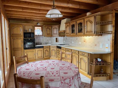 une cuisine avec des armoires en bois et une table à l'intérieur dans l'établissement Chalet l'Orme Châtel Réservation, à Châtel