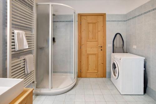 a bathroom with a shower and a washing machine at Casa Alù Larice in Bormio
