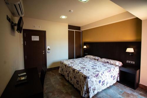 um quarto de hotel com uma cama e uma porta em Hostal Restaurante La Bartola em Santa Cruz