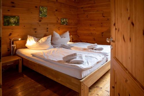 ein Schlafzimmer mit einem Bett in einem Holzzimmer in der Unterkunft Ferienwohnungen Erlebnisnaturhof in Aschau im Chiemgau