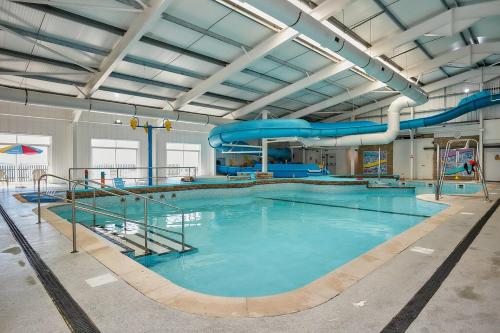a large indoor swimming pool with a water slide at 2-bedroom Holiday Home With Great Outdoor Space in Kidwelly